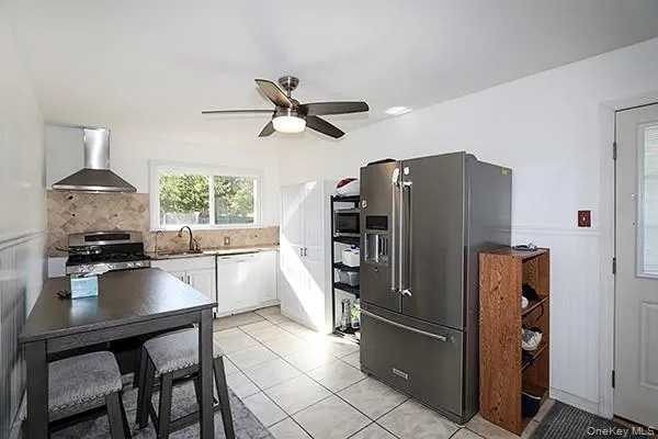 a kitchen with stainless steel appliances a refrigerator a stove a sink a dining table and chairs