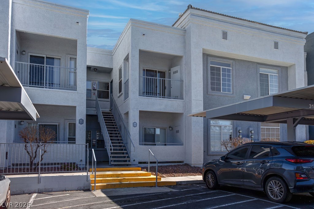 View of apartment building / complex with covered parking