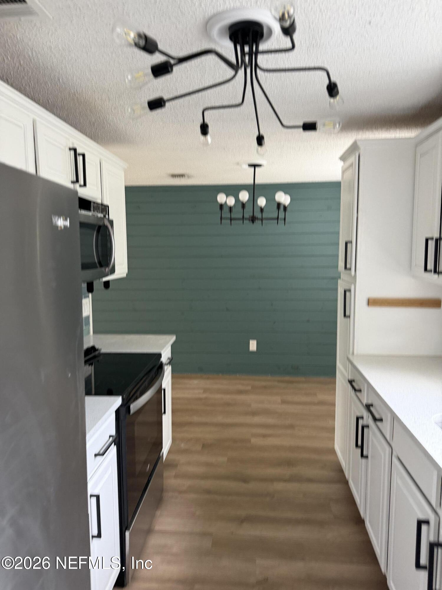 7539 Walden Road Jacksonville, FL 32244 - Photo 16 of 18 a kitchen with stainless steel appliances granite countertop a sink and a refrigerator