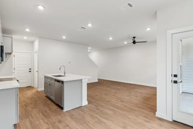 a view of kitchen with sink wooden floor and windows