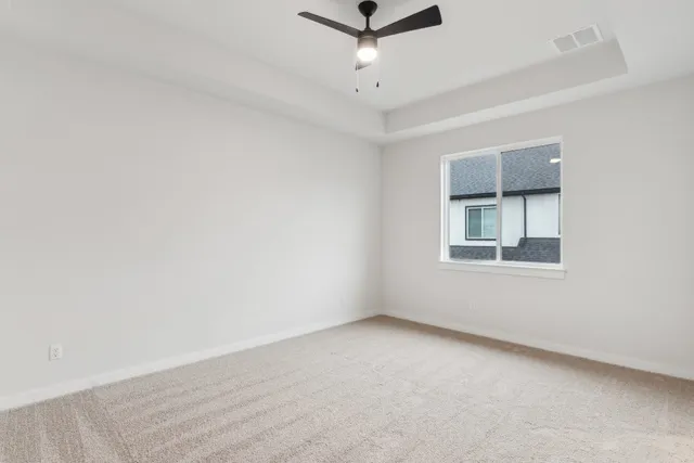an empty room with a window and a ceiling fan