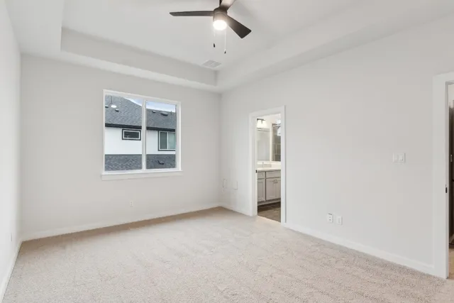 an empty room with windows and ceiling fan