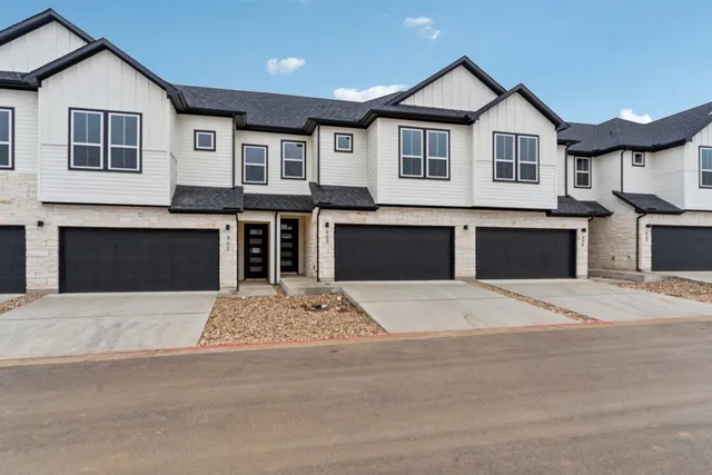 a front view of a house with yard and garage