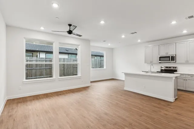 a view of an empty room with window and wooden floor