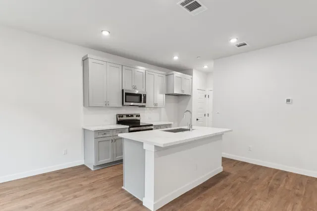 a kitchen with stainless steel appliances granite countertop a sink stove and microwave