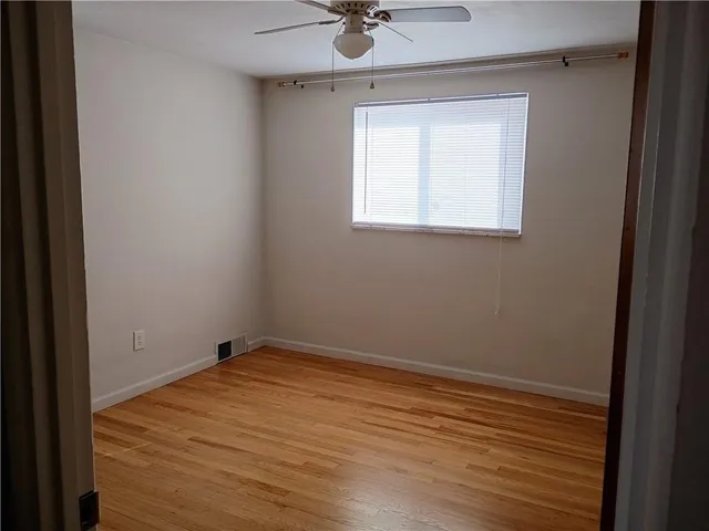 a view of a room with a window and wooden floor