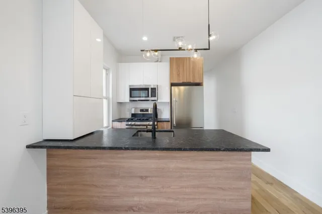 a kitchen with kitchen island a counter top space a sink and refrigerator