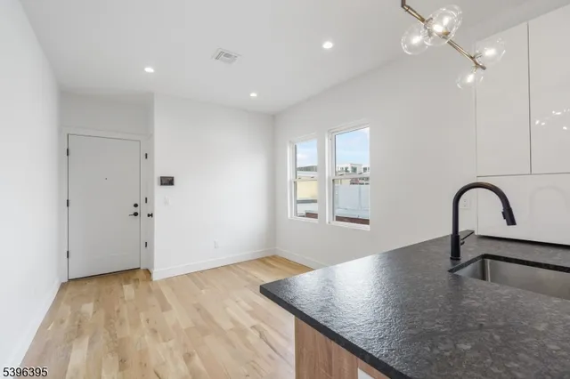 a view of a kitchen with a sink and dishwasher with wooden floor