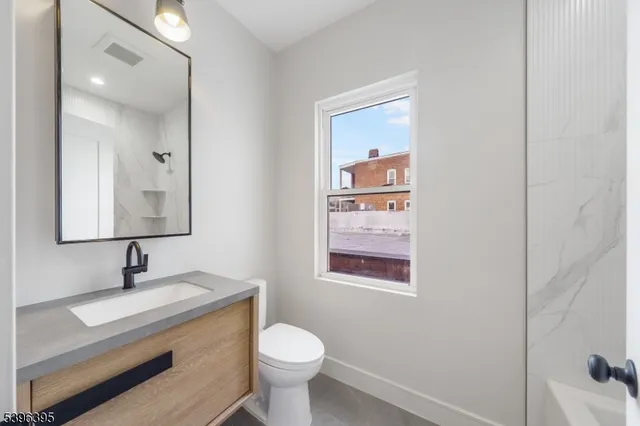 a bathroom with a toilet sink and mirror