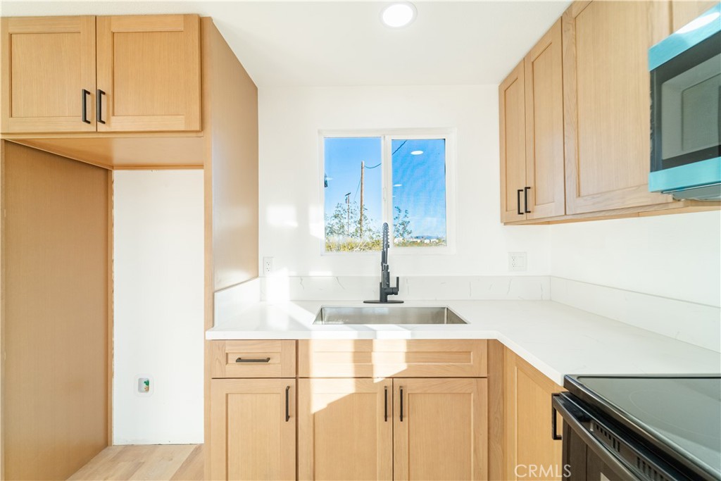 65125 Saturn Street Joshua Tree, CA 92252 - Photo 19 of 40 a kitchen with a sink and cabinets