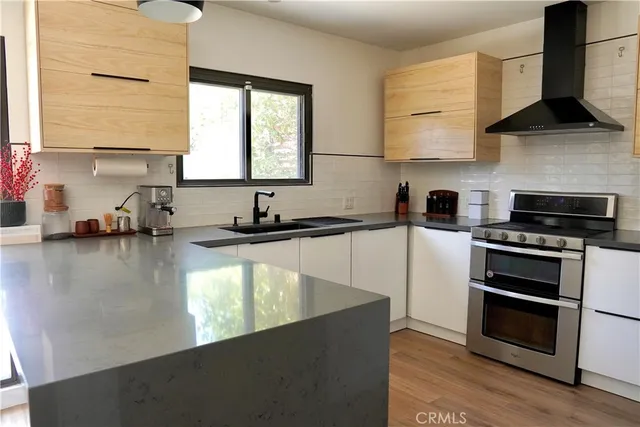 a kitchen with stainless steel appliances granite countertop a sink a stove and a microwave