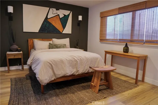 a bedroom with a bed a lamp and a large window