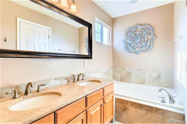 a bathroom with a tub sink and mirror