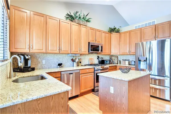 a kitchen with stainless steel appliances granite countertop sink microwave and refrigerator