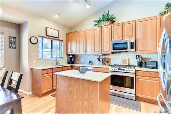 a kitchen with stainless steel appliances granite countertop a stove a sink and a microwave