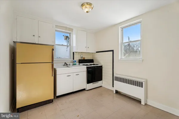 a kitchen with a refrigerator a stove top oven and cabinets
