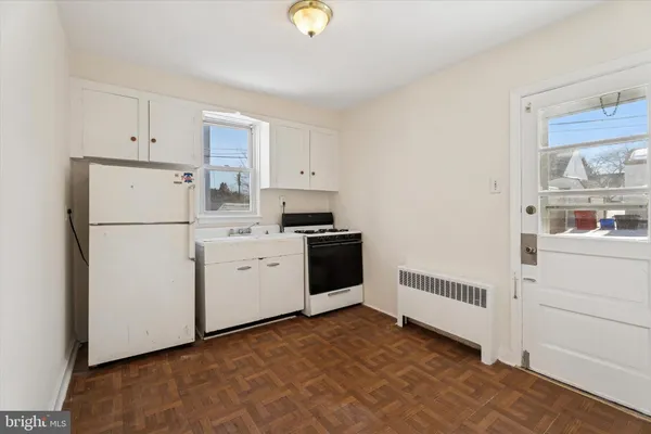 a kitchen with white cabinets and white appliances