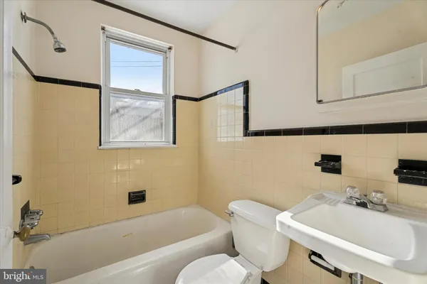 a bathroom with a sink and mirror with toilet