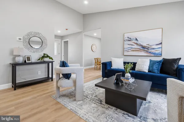 a living room with furniture a rug and kitchen view