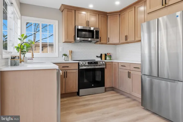 a kitchen with stainless steel appliances a stove a sink and a refrigerator