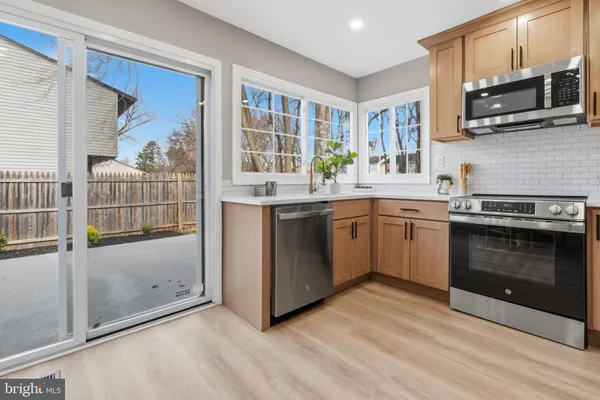 a kitchen with stainless steel appliances granite countertop a stove top oven a sink and a microwave