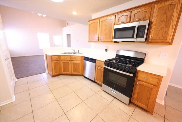a kitchen with stainless steel appliances kitchen island granite countertop a sink and cabinets
