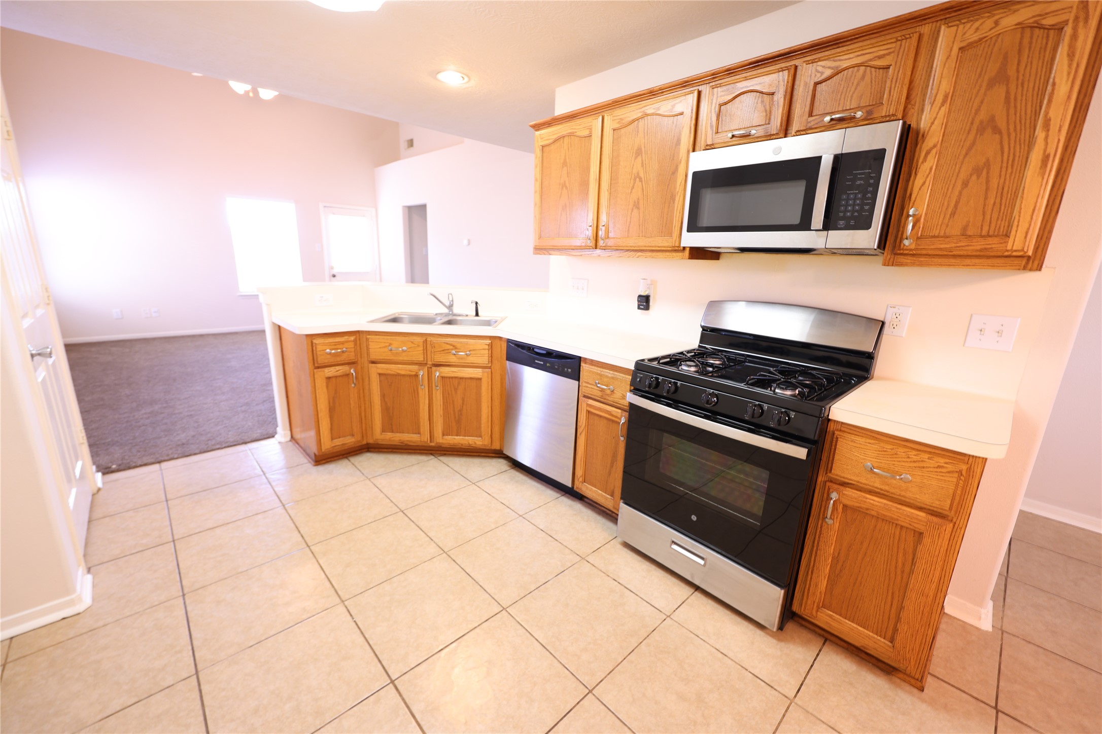 1007 Harrisburg Court Rosenberg, TX 77471 - Photo 12 of 24 a kitchen with stainless steel appliances granite countertop a stove a sink and a microwave