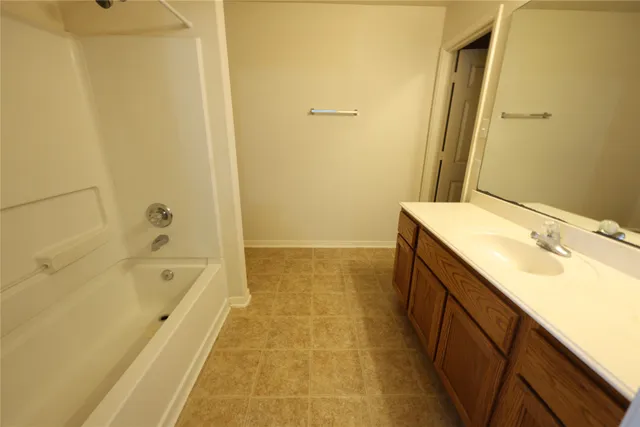 a bathroom with a tub sink and mirror