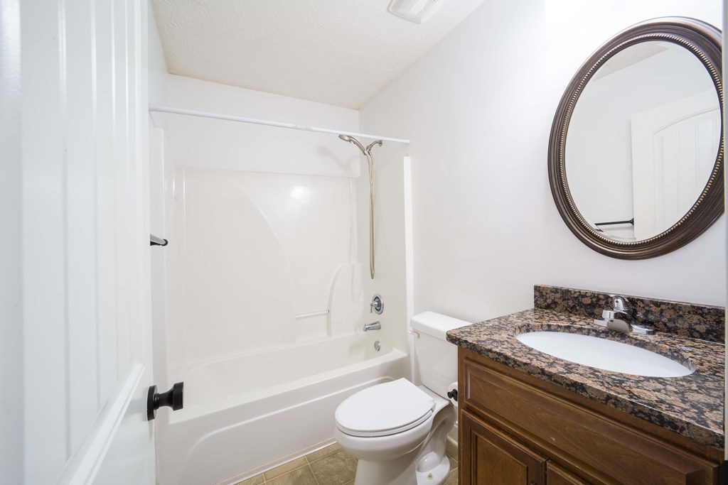 5151 Mccaghren Drive Columbus, GA 31909 - Photo 13 of 15 a bathroom with a granite countertop sink toilet a mirror and shower