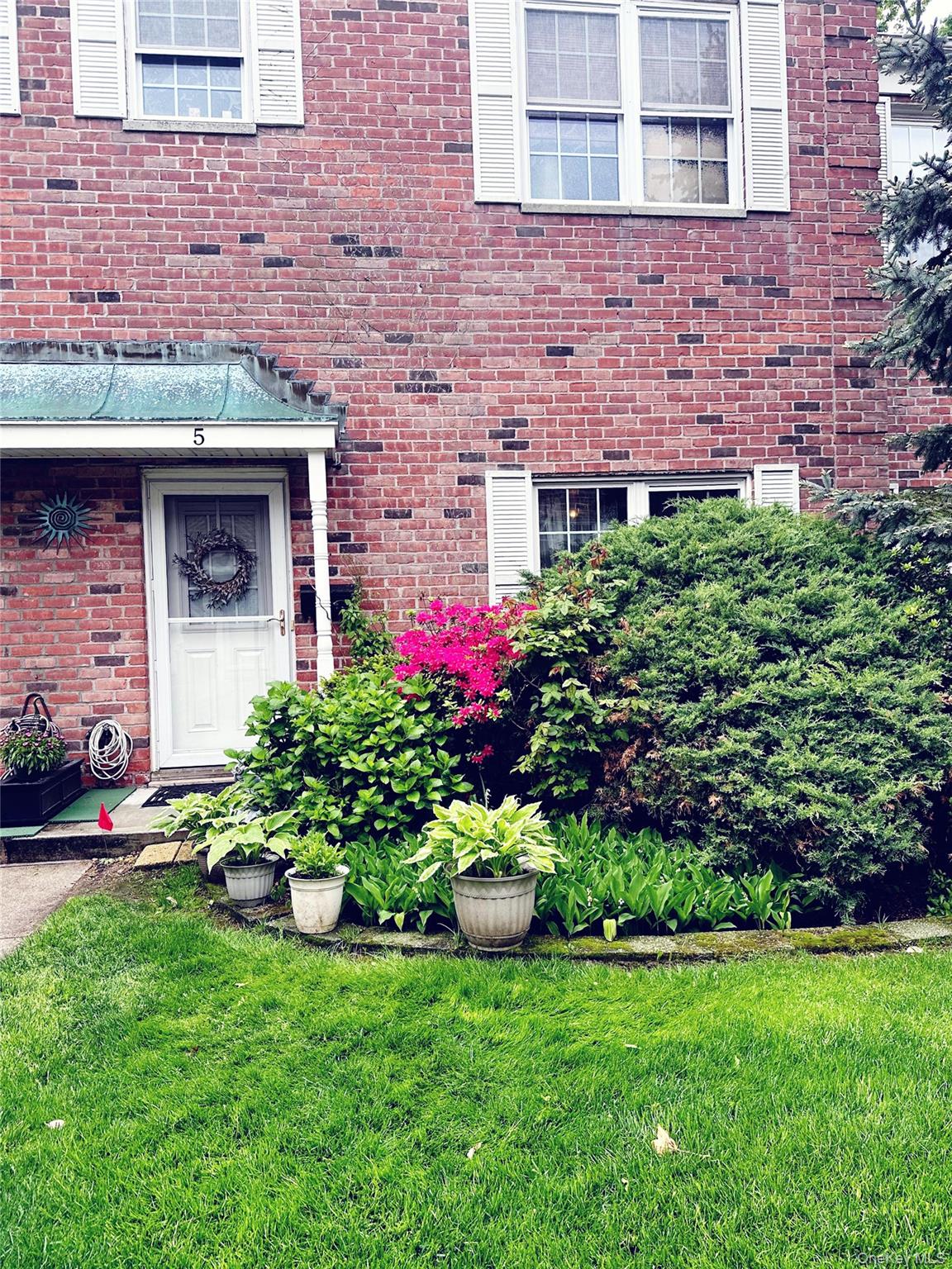 930 Merrick Road, Unit 5 Baldwin, NY 11510 - Photo 1 of 11 a front view of a house with a yard and outdoor seating