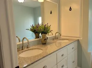 a bathroom with a granite countertop sink and a mirror