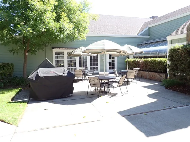 a view of a patio with table and chairs under an umbrella