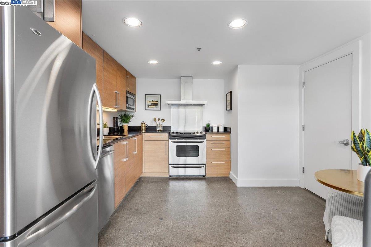 226 2nd Street Oakland, CA 94607 - Photo 7 of 28 a kitchen with white cabinets and stainless steel appliances
