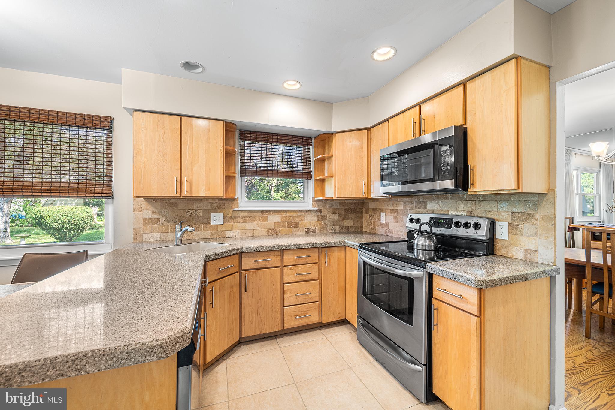 702 Brookhaven Road Wallingford, PA 19086 - Photo 11 of 31 a kitchen with stainless steel appliances granite countertop a stove top oven a sink dishwasher a refrigerator and a microwave