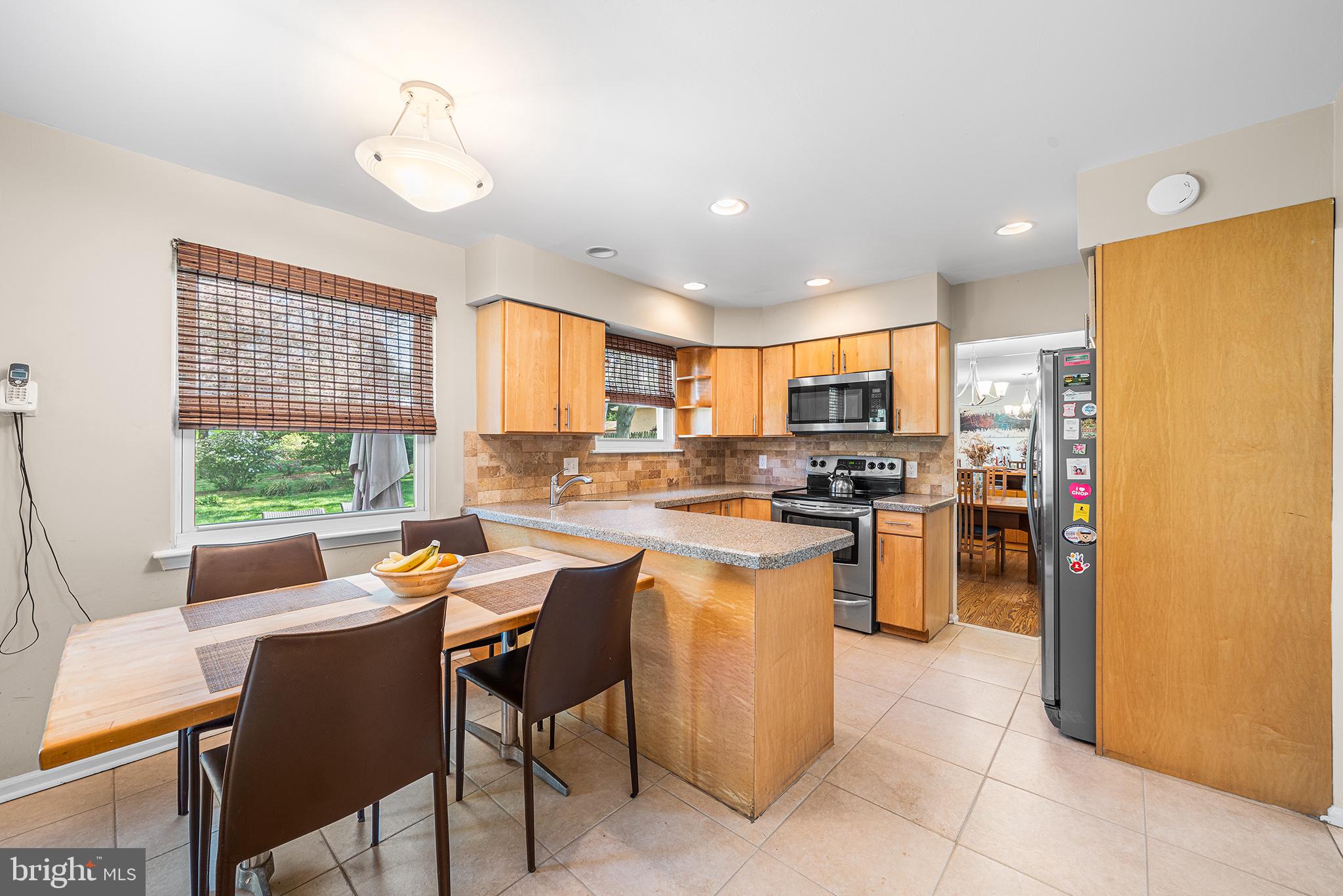 702 Brookhaven Road Wallingford, PA 19086 - Photo 12 of 31 a kitchen with a refrigerator a stove top oven a sink dishwasher and white cabinets with wooden floor