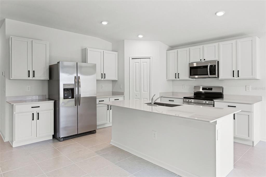 1993 Sarah Street Lake Wales, FL 33859 - Photo 4 of 31 a kitchen with stainless steel appliances a refrigerator sink and white cabinets