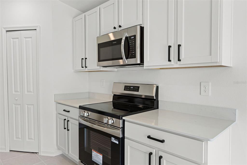 1993 Sarah Street Lake Wales, FL 33859 - Photo 6 of 31 a kitchen with white cabinets and stainless steel appliances