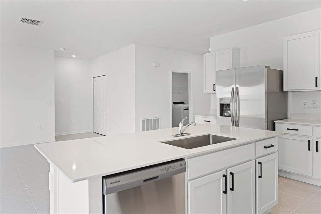 1993 Sarah Street Lake Wales, FL 33859 - Photo 7 of 31 a kitchen with a sink a stove a refrigerator and white cabinets