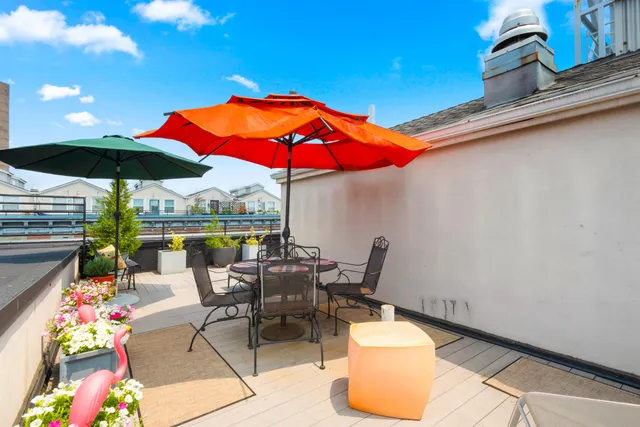 a view of a patio with a table and chairs under an umbrella