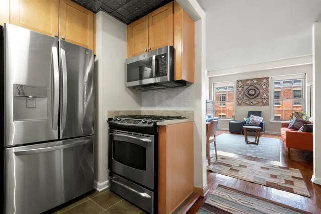 a kitchen with stainless steel appliances granite countertop a refrigerator stove and sink