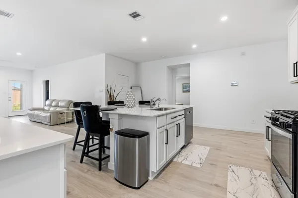 a kitchen with sink cabinets and stove top oven