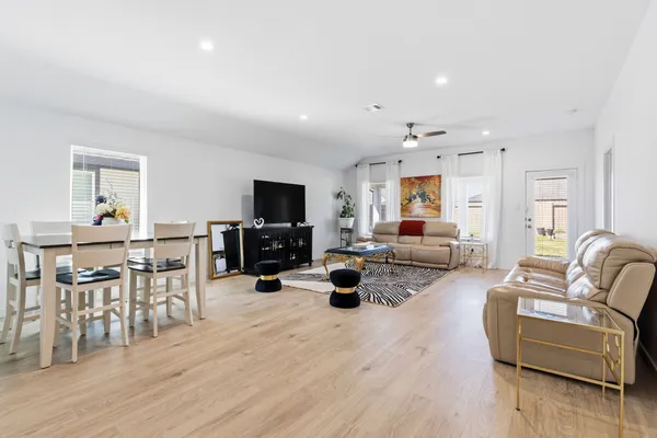 a living room with furniture flat screen tv and wooden floor