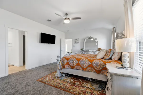 a bedroom with a large bed and a flat screen tv