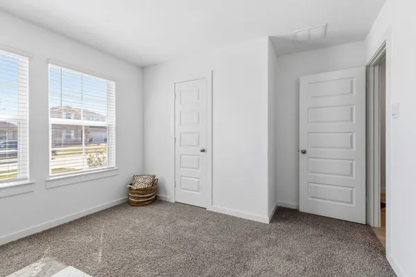 an empty room with windows and closet