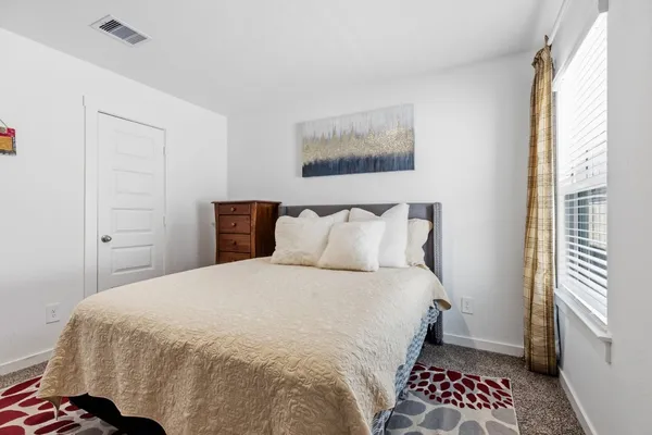 a bedroom with a large bed and a window