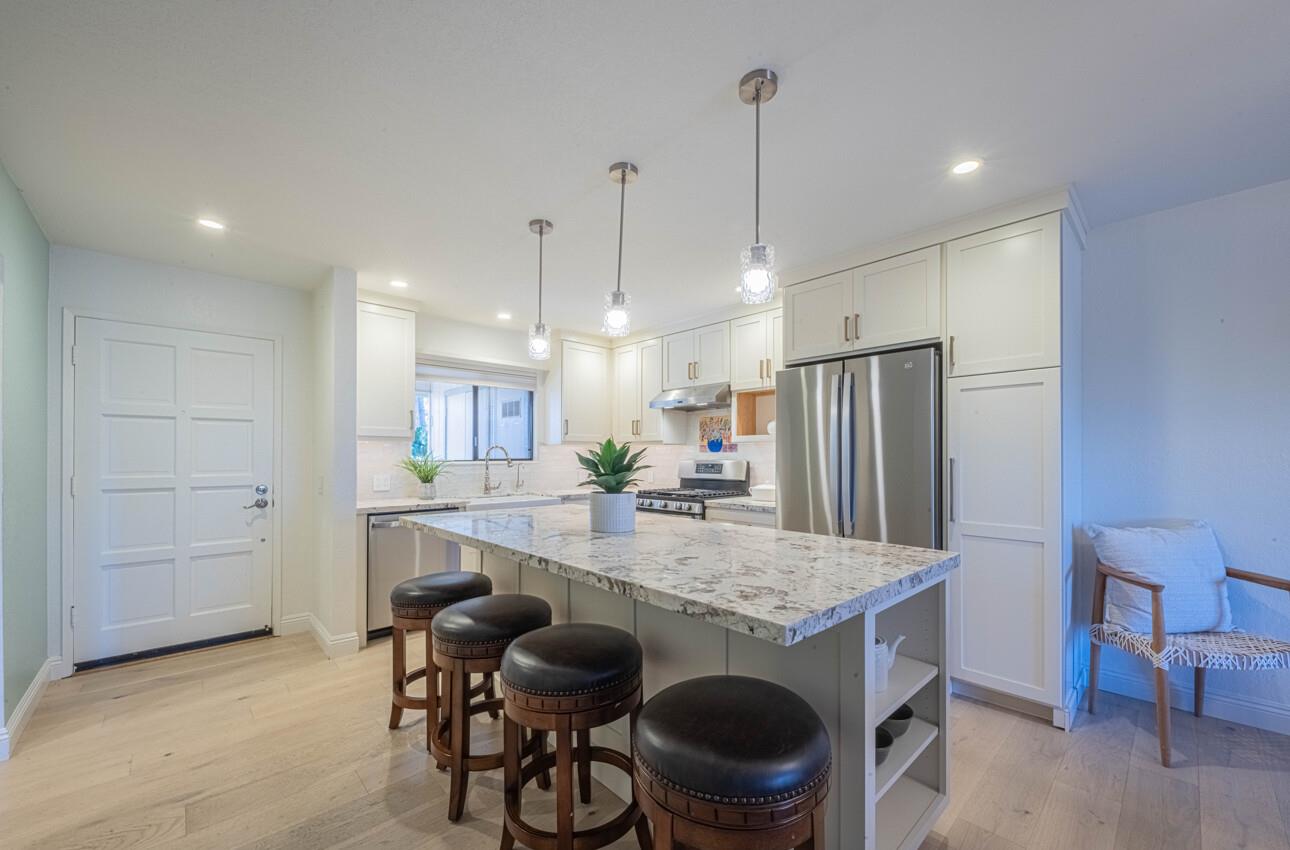 250 Forest Ridge Road, Unit 27 Monterey, CA 93940 - Photo 13 of 38 a kitchen with a table chairs refrigerator and microwave