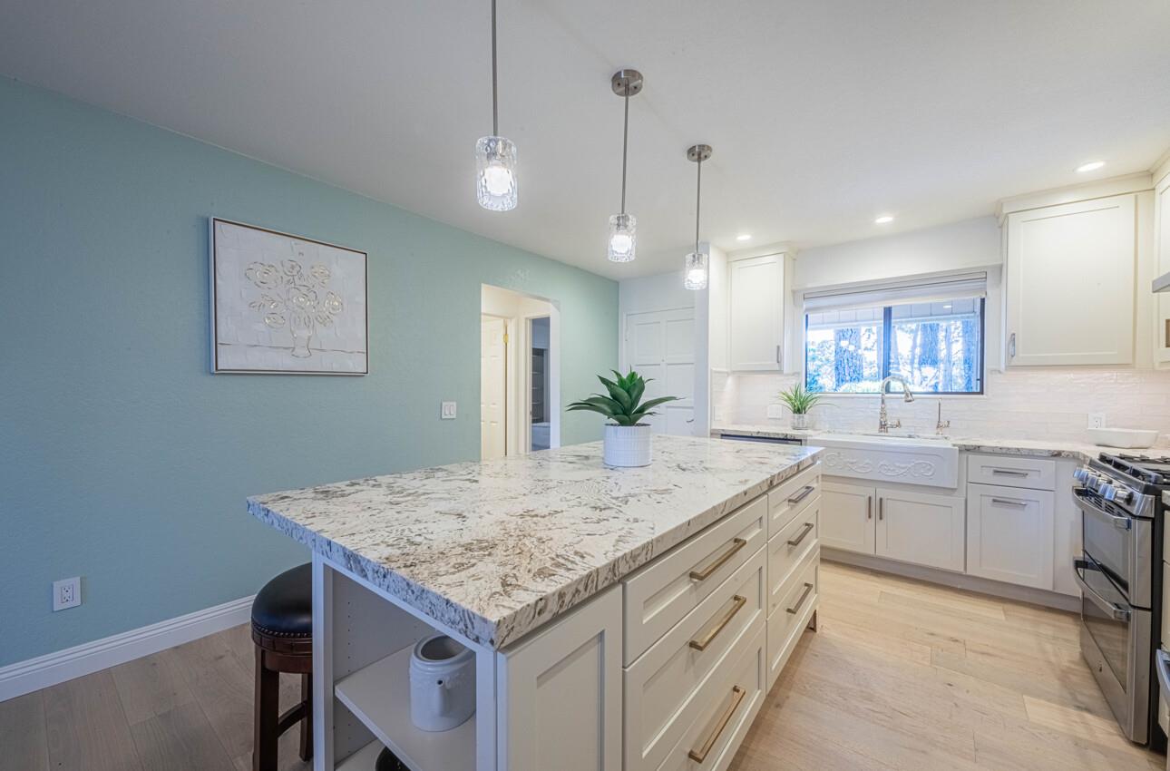 250 Forest Ridge Road, Unit 27 Monterey, CA 93940 - Photo 14 of 38 a kitchen with center island white cabinets and refrigerator