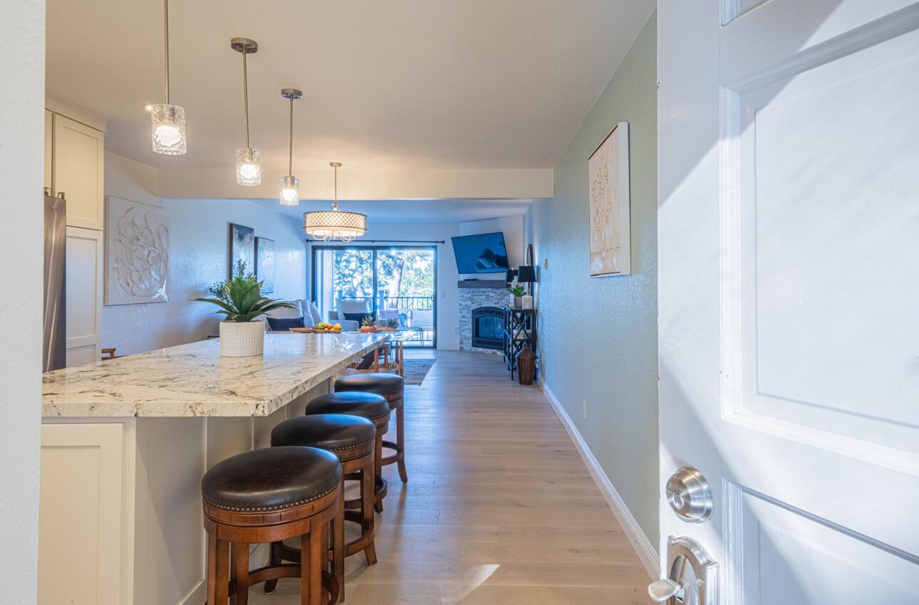 250 Forest Ridge Road, Unit 27 Monterey, CA 93940 - Photo 4 of 38 a dining hall with stainless steel appliances kitchen island granite countertop a refrigerator a sink a dining table and chairs with wooden floor