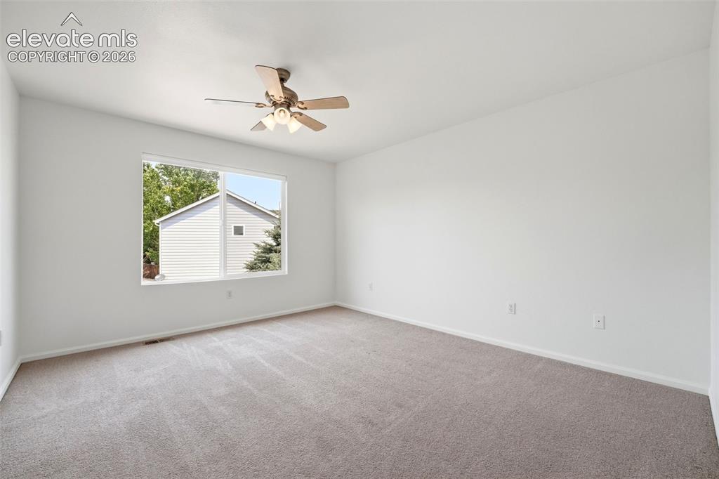7904 Coffee Road Peyton, CO 80831 - Photo 20 of 48 Bright interior space featuring a large window, neutral paint, and carpet flooring