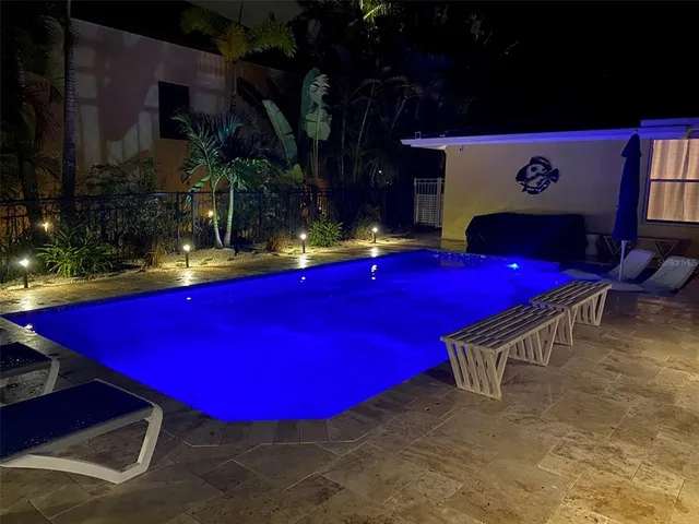 a room with pool table and potted plants